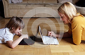 Mother and son working on two small laptops