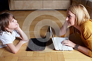 Mother and son working on two small laptops