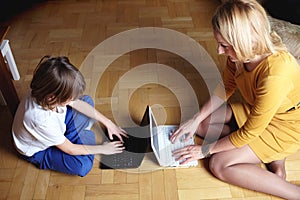 Mother and son working on two small laptops