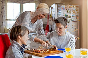 Mother and sons eating pizza for lunch