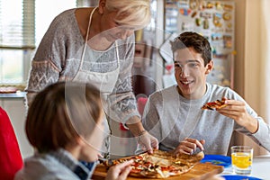 Mother and sons eating pizza for lunch