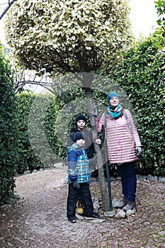 Mother and sons in green labyrinth in Nikitsky Botanical Garden