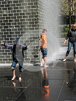 Mother and sons play in Crown Fountain, Millennium Park, Chicago