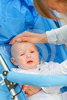 Mother soothing sitting in stroller crying baby