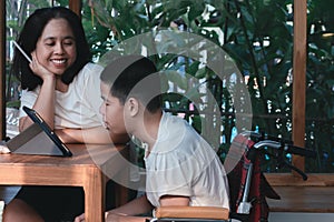 Mother and Special child on wheelchair use a tablet in a house