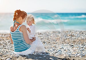 Mother spending time with baby on beach