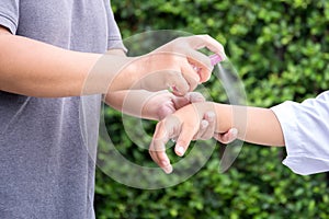 Mother spraying insect repellents on her son arm