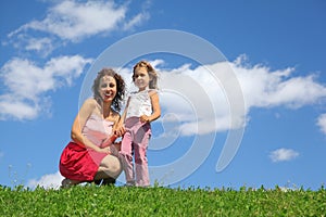 Mother squatting alongside with daughter photo