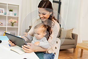 Mother student with baby and tablet pc at home