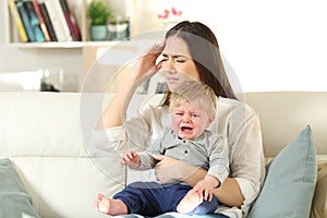 Mother suffering and baby crying desperately photo