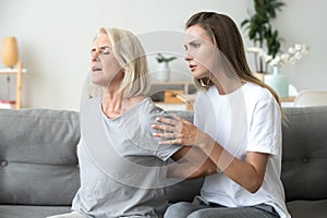 Mother suffering from back pain daughter feeling worry