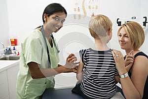 Mother Supporting Boy Receiving Injection