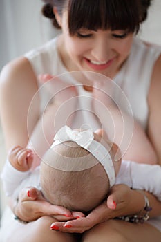 The mother supports the head of the baby lying on her lap