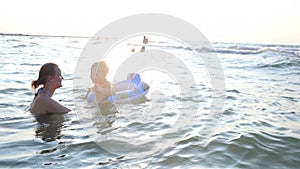 Mother swimming with her little boy in the sea