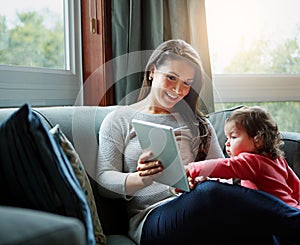 Mother, tablet and baby playing on sofa in living room for entertainment, bonding or time together at home. Happy mom