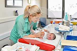 Mother take cares of her newborn baby in the maternity hospital. First bath