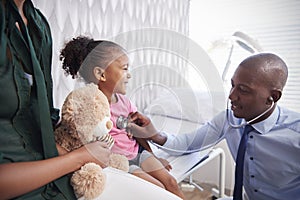 Mother Taking Daughter For Medical Exam In Doctors Office photo