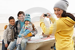 Mother Taking Family Photograph On Winter Beach