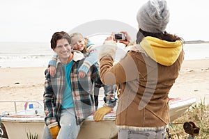 Mother Taking Family Photograph On Winter Beach