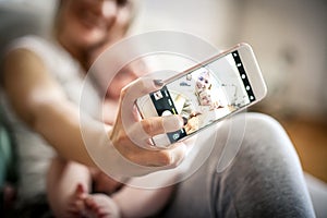 Mother taking self portrait of her and baby boy.