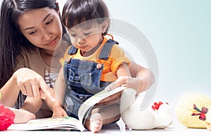 Mother teach child to read a book