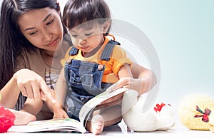 Mother teach child to read a book photo