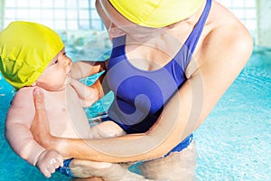 Mother teach little baby boy to swim in the pool