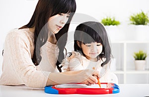 Mother or teacher helping child daughter to writing