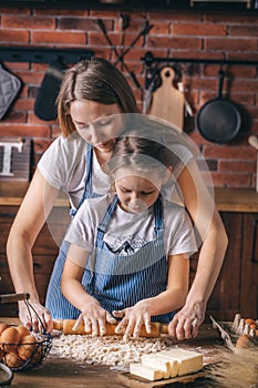 Mother teaches daughter prepare dough