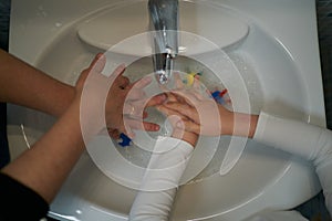 Mother teaches hand washing with virus models in water