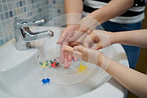 Mother teaches hand washing with virus models in water