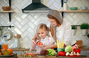 Mother teaches her child daughter how to cook in kitchen, parenthood and healthy lifestyle, nutrition