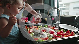 Mother teaches her little son how to cook healthy food in the kitchen. Lifestyle with caucasian people in single parent