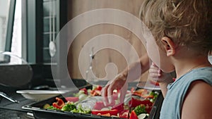 Mother teaches her little son how to cook healthy food in the kitchen. Lifestyle with caucasian people in single parent