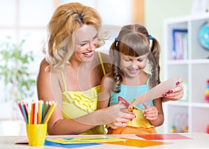 Mother teaches preschooler child to do craft items