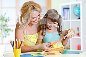 Mother teaches preschooler kid to do craft items