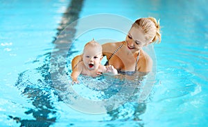 Mother teaching baby swimming pool