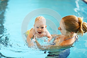 Mother teaching baby swimming pool