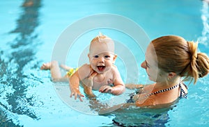 Mother teaching baby swimming pool