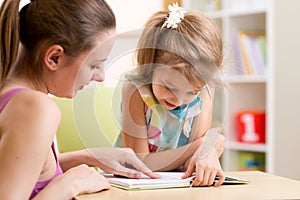 Mother teaching child daughter to read photo