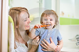 Mother teaching child teeth brushing