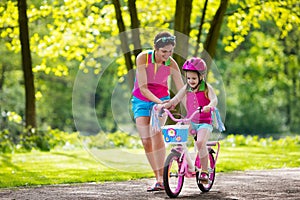 Mother teaching child to ride a bike