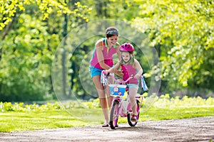 Mother teaching child to ride a bike