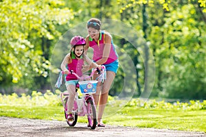 Mother teaching child to ride a bike