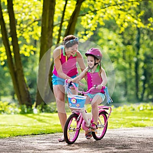 Mother teaching child to ride a bike