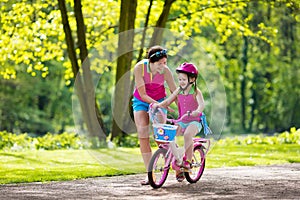 Mother teaching child to ride a bike