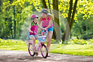 Mother teaching child to ride a bike