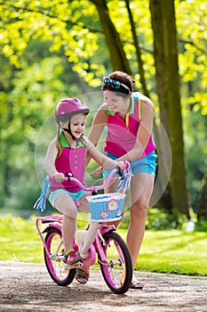 Mother teaching child to ride a bike