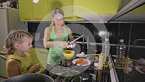 Mother teaching daughter smart girl learning to cook. Mistress children to cook a Neapolitan egg fried omelette from