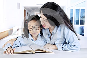 Mother teaching her daughter at home